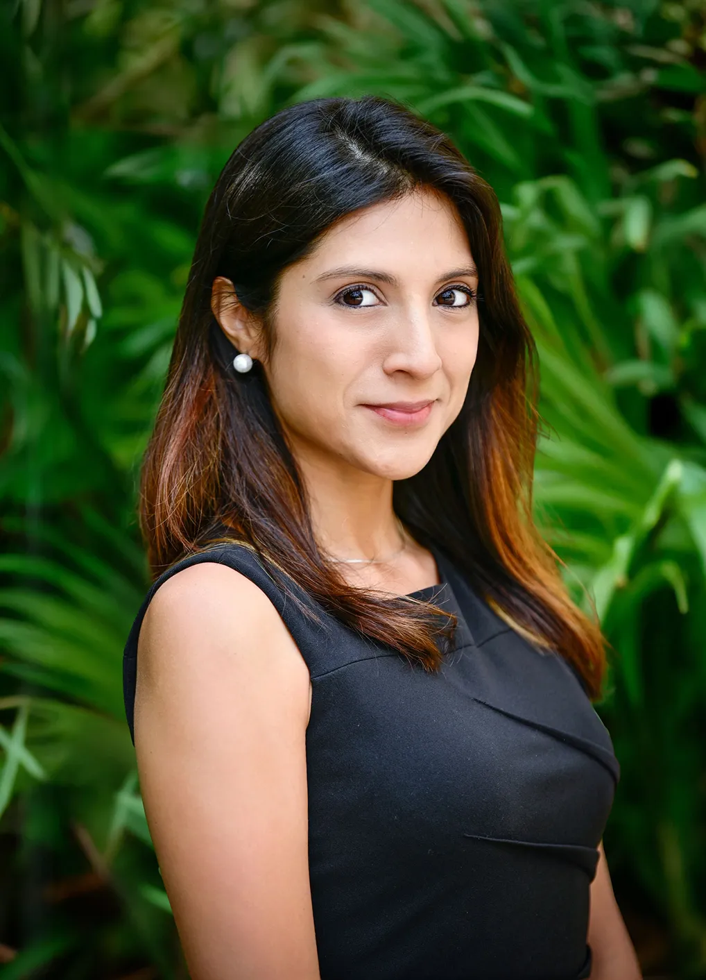 Portrait of Diana de Muranaka outdoors in front of green foliage